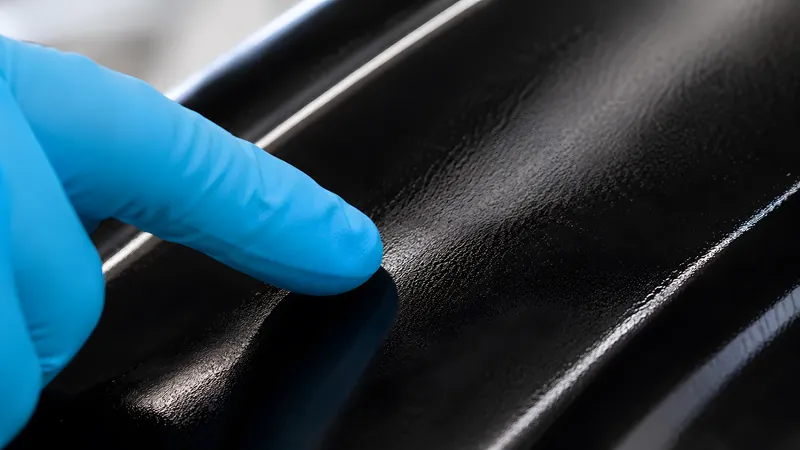 Fingertest mit Nitrilhandschuh auf dem angelierenden schwarzen Basecoat: noch klebrig, aber es bleibt kein Harz mehr am Finger